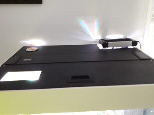 Schwarzer Tisch mit einem Projektor und Lichtreflexionen.