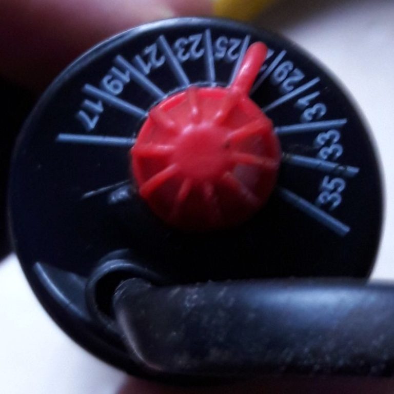 Schwarzes Einstellrad mit rotem Griff und Zahlen von 0 bis 35.